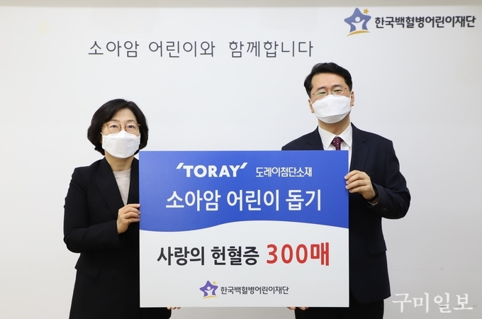 도레이첨단소재 김은주 상무(왼쪽)가 헌혈증 300매를 서선원 한국백혈병어린이재단 사무총장에게 전달하고 있다