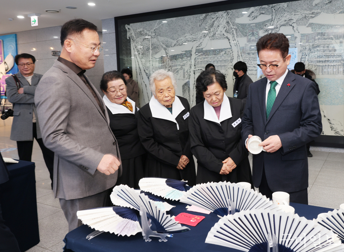 이철우 도지사가 김재욱 칠곡군수의 해설로 칠곡할매글꼴로 만든 굿즈를 살펴보고 있다.